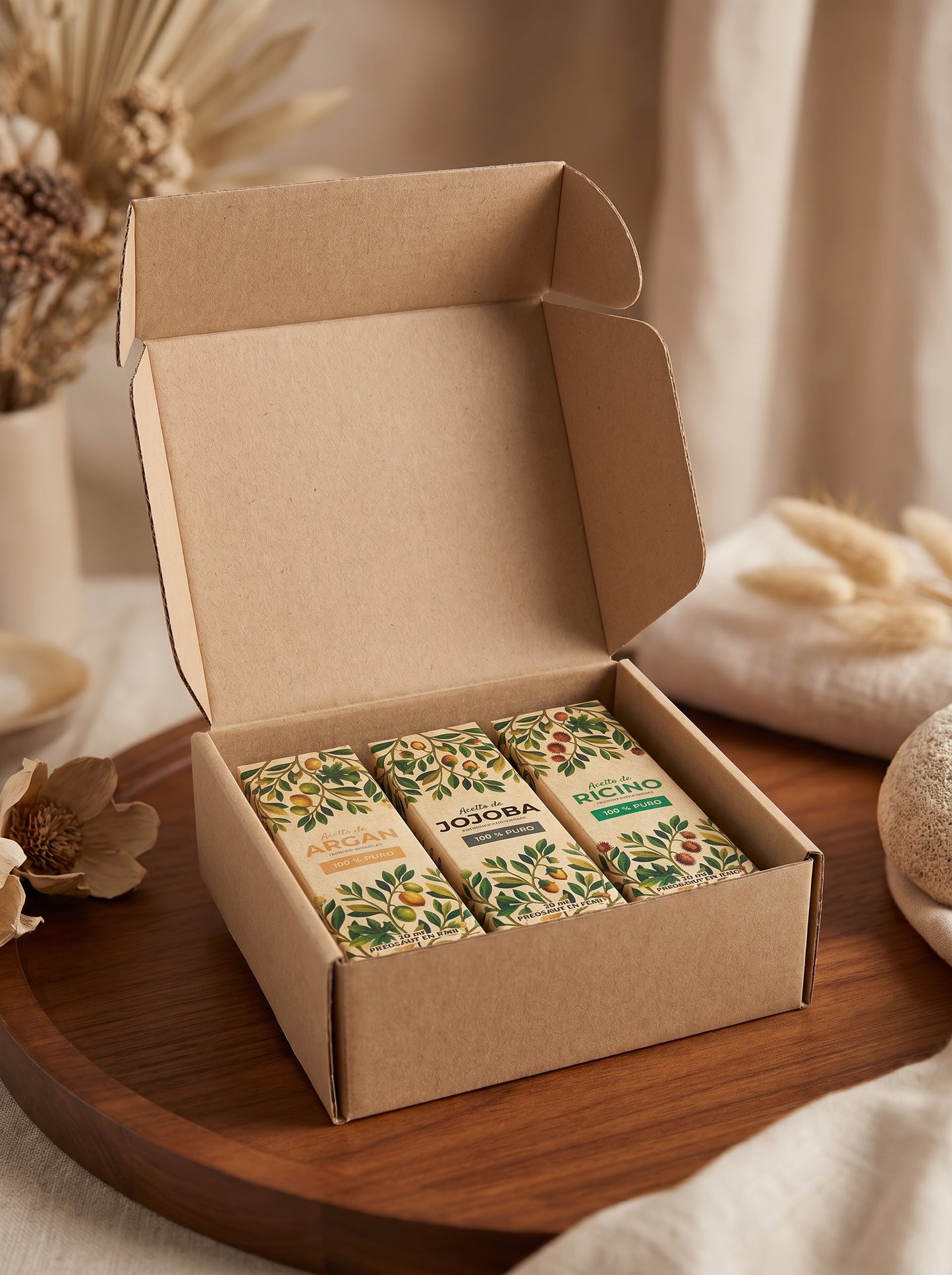 Caja de regalo ecológica con un set de tres aceites naturales de Amanitas: Argán, Jojoba y Ricino, presentados en empaques de cartón con diseño botánico sobre una bandeja de madera, ideal como kit de cuidado facial y capilar natural prensado en frío