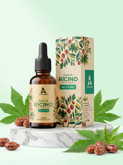 Frasco gotero de 30 ml de Aceite de Ricino 100% puro y prensado en frío de Amanitas, exhibido junto a su empaque con diseño botánico de hojas y semillas de Ricinus communis sobre una base de mármol blanco. Producto ideal para el cuidado natural del cabello y fortalecimiento de pestañas.
