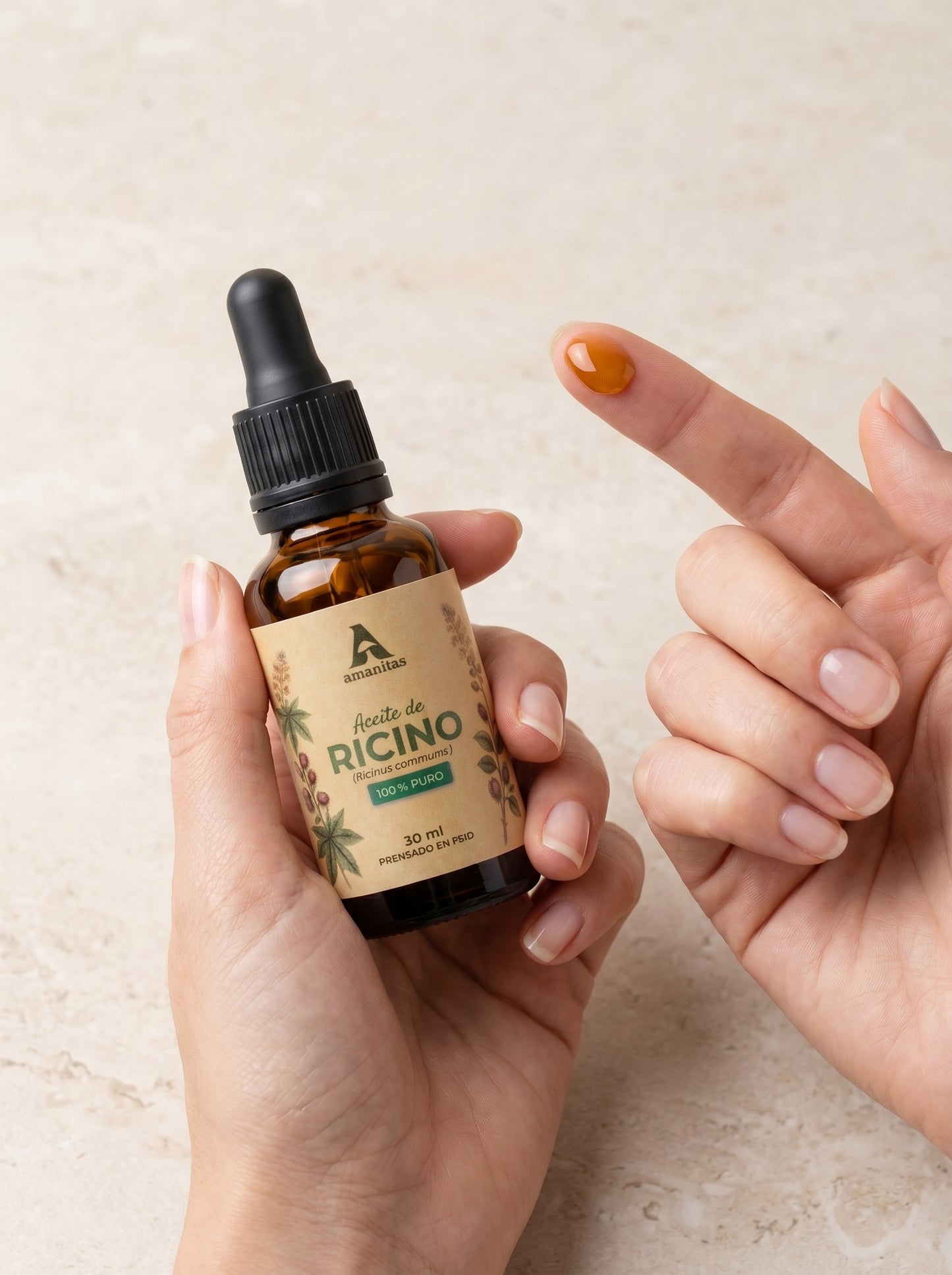 Persona mostrando la textura densa del Aceite de Ricino 100% puro Amanitas, aplicando una gota desde el gotero hacia la yema del dedo. Frasco de 30 ml con etiqueta botánica visible, ideal para tratamientos de fortalecimiento capilar y belleza natural.