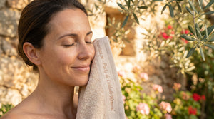 Mujer disfrutando de un momento de autocuidado y relajación con una toalla de Amanitas.pe, marca de packs de cuidado natural. La imagen refleja serenidad, belleza consciente y los valores de nuestra marca en un entorno natural.