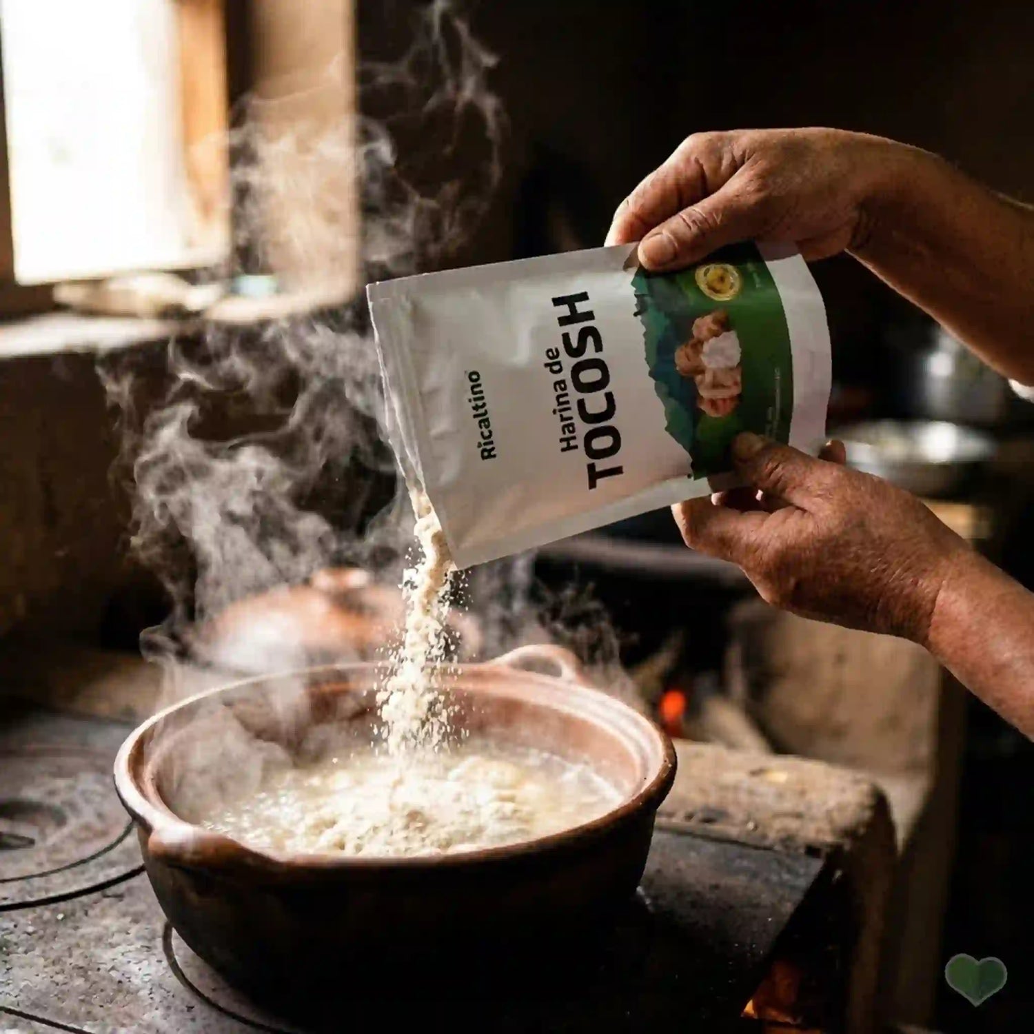 Persona vertiendo Harina de Tocosh Ricaltino en una olla de barro sobre fuego tradicional. Preparación artesanal de mazamorra de tocosh, potente penicilina natural para regenerar la mucosa gástrica y tratar la gastritis de forma efectiva en Amanitas.pe