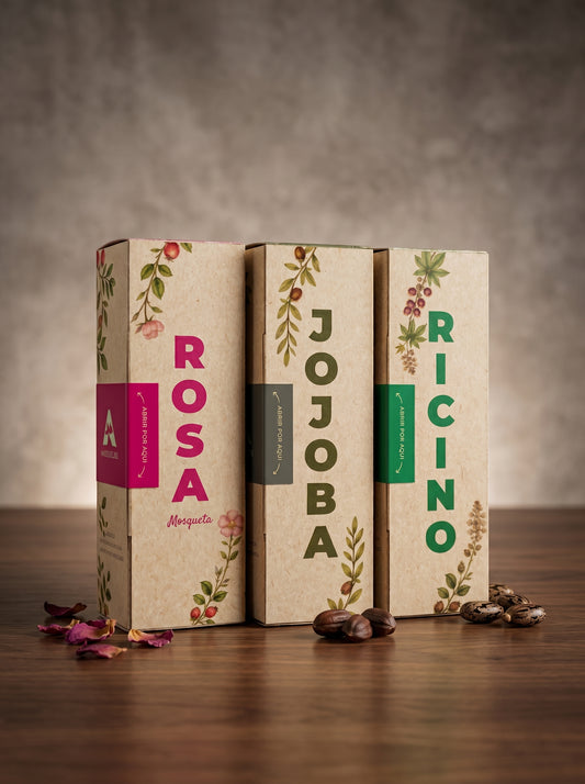 Set de tres aceites naturales de la marca Amanitas: Rosa Mosqueta, Jojoba y Ricino. Los empaques de cartón con diseño botánico están dispuestos sobre una superficie de madera, mostrando la presentación premium y ecológica de la colección de aceites prensados en frío.
